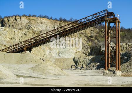 Riesige rostfreie Metallstrukturen für den Transport von Gesteinen in einem Dolomitbergbau, das Brechen von Kies, das Sortieren, das Transportieren von Gesteinen, den Hintergrund des blauen Himmels Stockfoto