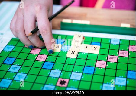 Brüsseler Altstadt, Belgien, 16. März 2024 - Dame spielt Scrable auf Niederländisch zu Hause Stockfoto