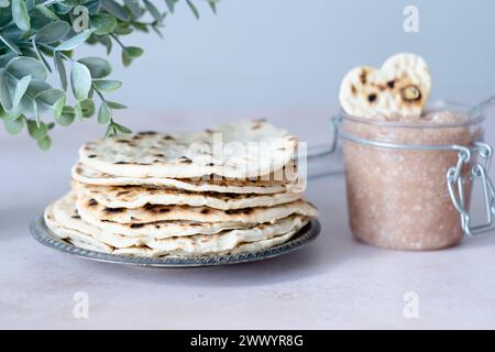 Handgemachte runde Matzo auf einem Teller. Süßes Gewürz mit Apfel-Walnuss-Charoset auf dem Tisch. Gesunde Ernährung. Jüdische Passahfeier. Stockfoto