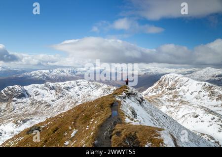 Ein Wanderer auf dem schmalen Kamm in der Nähe des Gipfels von Meall Garbh mit Creag na Caillich (links) & Beinn nan Eachan (rechts) Tarmachan Ridge Stockfoto