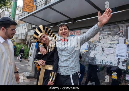 Junge Männer, einer ist als ägyptischer Pharao gekleidet, feiern Purim. Ultraorthodoxe Juden feiern Purim in Bnei Brak, Israel. Der Feiertag erinnert an die Rettung der Juden im alten Persien durch einen Plan zur Vernichtung. Ein fröhlicher Feiertag, der sowohl von weltlichen als auch von nichtweltlichen Juden gefeiert wird, vor allem indem sie sich in Kostümen kleiden und trinken, so der Talmud, „bis sie nicht unterscheiden können zwischen ‚verflucht ist Haman‘ und ‚gesegnet ist Mordechai‘. Stockfoto