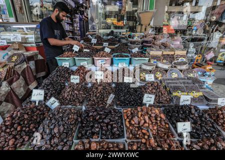 Bagdad, Irak. März 2024. Ein irakischer Verkäufer verkauft Datteln auf einem Markt während des heiligen Monats Ramadan. Datteln und Milch, Grundnahrungsmittel auf dem Ramadan-Tisch, bieten einen nahrhaften Start in die iftar-Mahlzeit. Quelle: Ameer Al-Mohammedawi/dpa/Alamy Live News Stockfoto