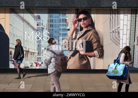 Drei junge Frauen, die an einem Marks & Spencer-Geschäft in der Princes Street, Edinburgh, Schottland, Großbritannien, vorbeilaufen. Stockfoto