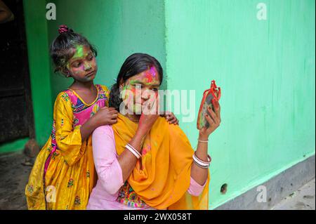 Sylhet, Bangladesch. März 2024. Ein Mädchen mit gemaltem Gesicht sieht aus, als ihre Mutter ihr Gesicht mit farbigem Puder malt, um das jährliche Hindufest der Farben zu feiern, das als Holi Festival bekannt ist und den Beginn des Frühlings markiert. Am 26. März 2024 in Sylhet, Bangladesch. (Kreditbild: © MD Rafayat Haque Khan/OKULARIS via ZUMA Press Wire) NUR REDAKTIONELLE VERWENDUNG! Nicht für kommerzielle ZWECKE! Stockfoto