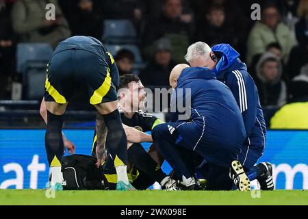 Der schottische Andrew Robertson (Mitte) wird während eines internationalen Freundschaftsspiels im Hampden Park in Glasgow wegen einer Verletzung behandelt. Bilddatum: Dienstag, 26. März 2024. Stockfoto