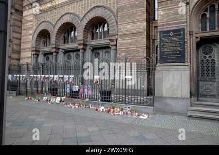 Vor der düsteren Kulisse der Neuen Synagoge in Berlin findet am 26. März 2024 eine ergreifende Gedenkstätte statt. Kerzen und Plakate richten die Tore aus, jede Flamme ist ein stiller Beweis für die tiefen Verluste, die am 7. Oktober 2023 während der verheerenden Angriffe der Hamas auf israelische Zivilisten und Soldaten angerichtet wurden. Die neue Synagoge, einst ein Leuchtturm des jüdischen Wohlstands und heute ein Symbol der Widerstandskraft angesichts der Widrigkeiten, ist ein stiller Zeuge dieser feierlichen Versammlung. Die Plakate, die mit Gesichtern von Geiseln und Opfern verziert sind, erinnern Passanten an die Personen hinter den erstaunlichen Figuren: 1.139 Tote, darunter Stockfoto