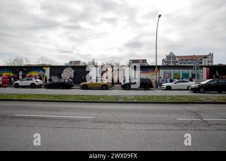 26. März 2024, Berlin, Deutschland - Ein Tourist fängt den Moment in der East Side Gallery Ein, wo Dmitri Vrubels berühmtes Wandgemälde "mein Gott, hilf mir, diese tödliche Liebe zu überleben" mit der Zeit den sozialistischen Brüderkuss zwischen Leonid Breschnew und Erich Honecker friert. Dieses eindrucksvolle Kunstwerk, das sich den Überresten der Berliner Mauer gegenübersieht, steht als mächtiges Symbol politischer Geschichte und als dauerhafter Reiz der Berliner Freilichtgalerie und lädt zur Reflexion über die komplexen Narrative von Solidarität und Spaltung ein. (Foto: Michael Kuenne/PRESSCOV/SIPA USA) Stockfoto