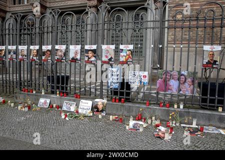 Berlin, Deutschland. März 2024. Vor der düsteren Kulisse der Neuen Synagoge in Berlin findet am 26. März 2024 eine ergreifende Gedenkstätte statt. Kerzen und Plakate richten die Tore aus, jede Flamme ist ein stiller Beweis für die tiefen Verluste, die am 7. Oktober 2023 während der verheerenden Angriffe der Hamas auf israelische Zivilisten und Soldaten angerichtet wurden. Die neue Synagoge, einst ein Leuchtturm des jüdischen Wohlstands und heute ein Symbol der Widerstandskraft angesichts der Widrigkeiten, ist ein stiller Zeuge dieser feierlichen Versammlung. Die Plakate, die mit Gesichtern von Geiseln und Opfern verziert sind, erinnern Passanten an die Personen hinter den Stummeleien Stockfoto