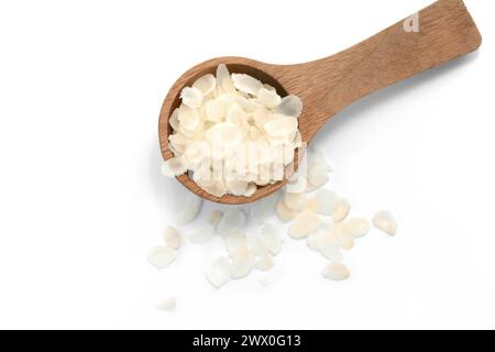 Abgeflachte Reisflocken in einem Holzlöffel isoliert auf weiß. Stockfoto