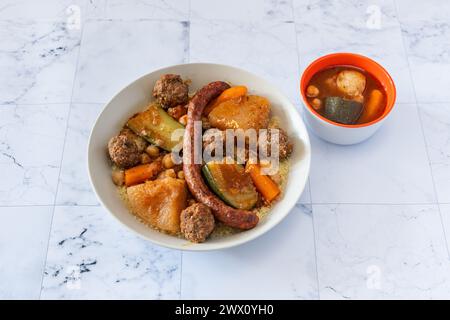 Ein fantastischer traditioneller orientalischer und heißer Couscous auf einem Teller mit Harissasauce Stockfoto