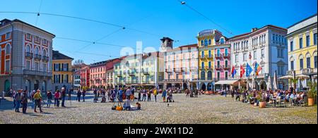 LOCARNO, SCHWEIZ - 26. MÄRZ 2022: Panorama der historischen Piazza Grande mit einer Reihe von bunten Häusern mit Arkaden, Geschäften, Ständen und Outdoor Stockfoto