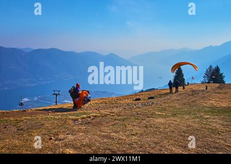 Gleitschirmfliegen über den Berg Cimetta bietet ein aufregendes Erlebnis mit atemberaubendem Blick auf die umliegende Landschaft und den Lago Maggiore, Tessin und Switz Stockfoto