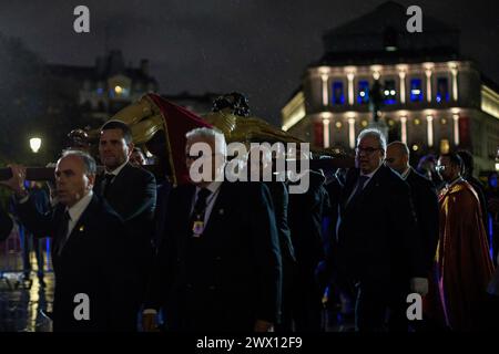 Mitglieder der Bruderschaft des Christus der Halberdiers tragen auf ihren Schultern das Bild des Christus der Halberdiers, als sie die Militärkathedrale in Richtung Königspalast verlassen. In diesem Jahr verzögerte der Regen ihre Abreise. Die Mitglieder der Königlichen Kongregation des Heiligen Christus des Glaubens, Christus der Helleberdiers und Maria Unbefleckte Königin der Engel der Kathedrale der Streitkräfte führen die traditionelle Übertragung des Bildes des Christus der Helleberdiers in den Königlichen Palast von Madrid durch, um es für die Prozession vorzubereiten, die am nächsten Karfreitag durch die Straße geht Stockfoto