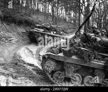 Originalunterschrift: Amerikanische Panzer, Teil der neuen alliierten Offensive, ziehen über eine schmale, schlammige Straße im Hurtgen Forest nach vorne. Deutschland, 18.11.44. 803. Mrd., 3. ARMD Div, südwestlich von Duran, Deutschland. Stockfoto