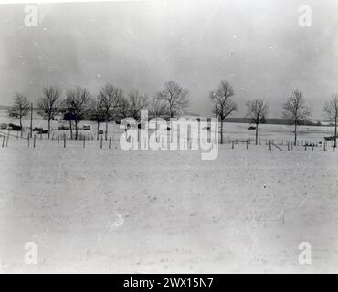 Fotos des Zweiten Weltkriegs: Originalunterschrift: General Pattons gepanzerte Truppen, die 101 Luftlandemänner entlastet haben, die Bastogne zehn Tage lang hielten, beginnen ihre Fahrt über Bastogne hinaus. In der Mitte des Fotos explodiert die deutsche Artillerie." CA. Dezember 1944 Stockfoto