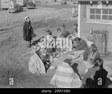 Wind River Indianerreservat, Wyoming: Indianer sitzen auf dem Boden und essen, während die Frau auf CA. 1938 Stockfoto