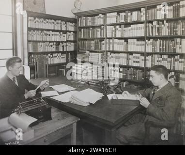 Dieses Foto zeigt zwei Studenten der Brown University, die die Harris Collection of American Poetry katalogisieren und in der John Jay Library als Teil eines College-Hilfsprojekts der National Youth Administration (NYA) CA spielen. 1939-1943 Stockfoto