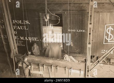 Pillsbury Mehl Mills, Minneapolis, MN - Entladen von Weizen mit kraftbetriebenen Schaufeln, Arbeiter und Soldat im Bild ca. 1917 Stockfoto