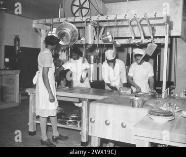 Originalunterschrift: WAAC-Köche bereiten zum ersten Mal in der neuen Küche in Fort Huachuca, Arizona, ein Abendessen zu. 1942 Stockfoto