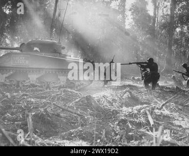 Die Yanks wischen Bougainville ab. Nachts infiltrierten die Japaner amerikanische Linien. In Dawn gingen die Doughboys raus und töteten sie. Dieses Foto zeigt Panzer, der vorwärts geht, Infanteristen folgen in seinem Cover ca. März 1944 Stockfoto