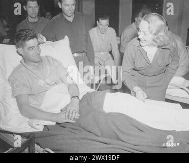 Marlene Dietrich, Filmschauspielerin, signiert den Besatz auf dem Bein eines verletzten Soldaten in einem Krankenhaus der Vereinigten Staaten in Belgien, wo sie die GIS CA unterhält. November 1944 Stockfoto