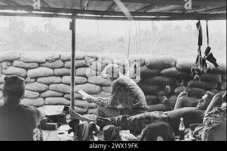 Vietnam war: Ein Berater der Spezialkräfte einer Montagnard-Kampftruppe, erhält die Chance, seine Post in Phey-Shuron zu lesen, einem Lager, das im zentralen Vietnam-Hochland ca. 1964 Stockfoto