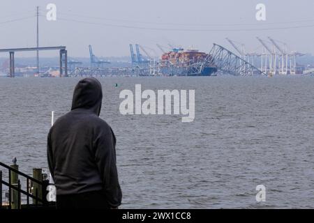 Die Zuschauer sehen die Rettungsbemühungen der Behörden, als sie nach Personen suchen, die unter den Überresten der Francis Scott Key Bridge außerhalb von Baltimore, Maryland, gefangen sind, nachdem ein Containerschiff am Dienstag, den 26. März 2024 in Baltimore, MD, USA, die Brücke getroffen hatte. Sechs Menschen werden vermisst und sind vermutlich tot, nachdem ein Containerschiff die Francis Scott Key Bridge in Baltimore getroffen hat. Die Küstenwache sagte, sie habe ihre Suche eingestellt und eine Erholungsbemühungen begonnen. Mehrere Fahrzeuge überquerten die Brücke, die mehr als 1,6 km lang ist, als sie zusammenfiel Stockfoto