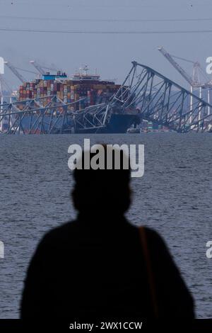 Die Zuschauer sehen die Rettungsbemühungen der Behörden, als sie nach Personen suchen, die unter den Überresten der Francis Scott Key Bridge außerhalb von Baltimore, Maryland, gefangen sind, nachdem ein Containerschiff am Dienstag, den 26. März 2024 in Baltimore, MD, USA, die Brücke getroffen hatte. Sechs Menschen werden vermisst und sind vermutlich tot, nachdem ein Containerschiff die Francis Scott Key Bridge in Baltimore getroffen hat. Die Küstenwache sagte, sie habe ihre Suche eingestellt und eine Erholungsbemühungen begonnen. Mehrere Fahrzeuge überquerten die Brücke, die mehr als 1,6 km lang ist, als sie zusammenfiel Stockfoto