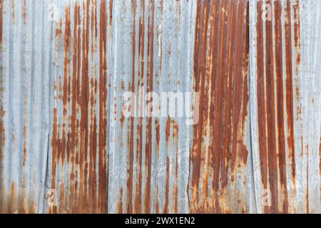 Vorderansicht einer Baustellenwand aus rostigem und verwittertem Wellblech. Hochauflösender, strukturierter Rosthintergrund im Vollformat. Stockfoto