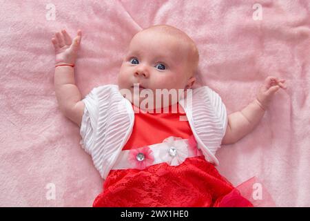 Baby in einem Kleid, in einer rosa Komnata. Geburtstag, ein Jahr Stockfoto