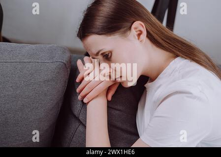 Nahaufnahme des unglücklichen, traurigen jungen Frauenausdrucks Gesicht, das über Probleme, Schwierigkeiten, das Gefühl von Versagen und erschöpft, an Einsamkeit leidet Stockfoto