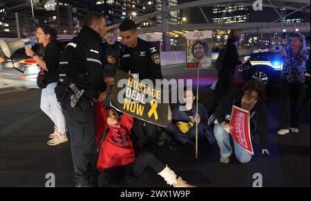 Israelische Polizei trifft auf Familien israelischer Geiseln und deren Anhänger, die den Ayalon Highway, eine der wichtigsten Autobahnen Israels, blockieren. während einer Demonstration nach dem Zusammenbruch der letzten Runde von Geiselverhandlungen in Katar und der Forderung nach einem Abkommen zur Freilassung israelischer Geiseln, die am 26. März 2024 im Gazastreifen in Tel Aviv, Israel, stattfanden. Stockfoto