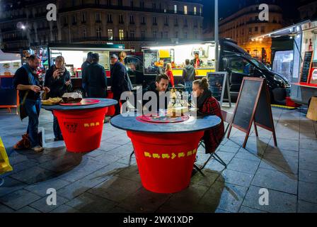 Paris, Frankreich, Paare, die Mahlzeiten teilen, an Tischen, in der Nähe von French Street Food Trucks, parken vor dem Bahnhof Gare Saint Lazare, Händler, Essen im Restaurant Stockfoto