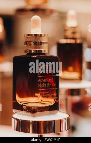 Braune Flasche Estee Lauder Advanced Night Repair Synchronized Recovery Gesichtsserum auf goldenem Standfuß. Hautpflegeprodukte, Schönheitskonzept Stockfoto