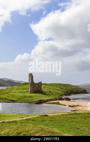 Die antiken Ruinen von Ardvreck Castle, die auf einer lebhaften grünen Landzunge thront, überblicken einen friedlichen See mit einer Kulisse aus sanften Hügeln unter einem riesigen Himmel Stockfoto