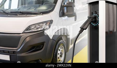 Elektrischer Lieferwagen mit Ladestation für Elektrofahrzeuge. Stockfoto