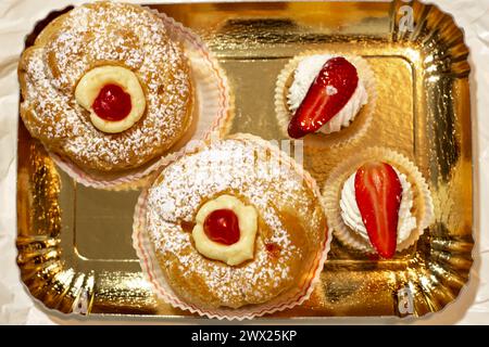 Italienisches Dessert Zeppole di San Giuseppe, Zeppola gebackene Puffs aus Choux-Gebäck, gefüllt und dekoriert mit Vanillecreme und Kirsche. Traditionell Stockfoto