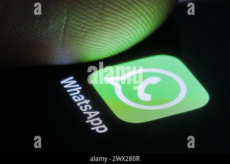 Die App von WhatsApp ist auf deinem Smartphone neben einem Finger zu sehen. Berlin, 27.03.2024. Berlin Deutschland *** die WhatsApp App ist auf zu sehen Stockfoto