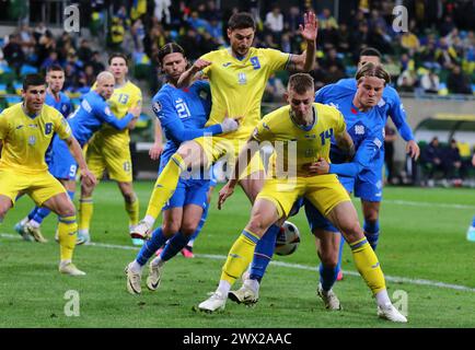 Breslau, Polen. März 2024. Ukrainische (in Gelb) und isländische Spieler kämpfen während ihres Play-off-Spiels zur UEFA EURO 2024 in der Tarczynski Arena in Breslau um einen Ball. Quelle: Oleksandr Prykhodko/Alamy Live News Stockfoto