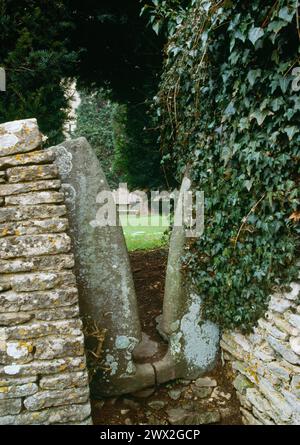 Vertikaler Steinstiel von außen mit Blick auf die Kirche. Hawkesbury, St. Mary the Virgin Churchyard, Gloucestershire, England. Stockfoto