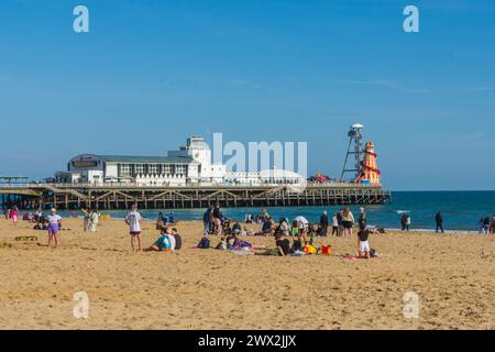 Bournemouth, Großbritannien - 8. April 2023: Menschen am Strand vor dem Bournemouth Pier. Stockfoto