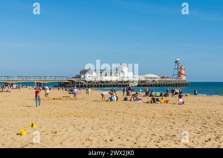 Bournemouth, Großbritannien - 8. April 2023: Menschen am Strand vor dem Bournemouth Pier. Stockfoto