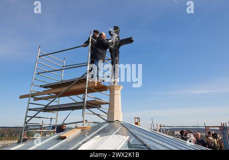 Nach fast zehn Jahren ist das Turmkreuz auf die evangelische Friedenskirche im Potsdamer Park Sanssouci zurueckgekehrt. Das im November 2014 aus Sicherheitsgruenden abgenommene mehr als drei Meter hohe Kreuz wurde am Mittwoch 27.03.2024 wieder auf dem Campanile, dem Glockenturm der Kirche, enthuellt. Foto v.l.: Andreas Kitschke, Architekt und Denkmalpfleger Frank Karalus, Projektleitung, Abteilung Baudenkmalpflege und Liegenschaften, SPSG, enfernten gemeinsam die Schutzhuelle der 1850 errichteter Turm wird seit Februar 2022 saniert. Das Dach des rund 42 Meter hohen Campanile sei inzwischen inst Stockfoto