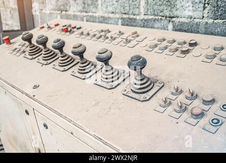 Die alte Steuereinheit ist mit Staub bedeckt. Joysticks zur Steuerung von Geräten im Werk Stockfoto