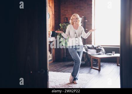 Großes Porträt der alten Dame Arme begrüßen Sie durch Türbekleidung weiße Strickjacke Loft Innenhaus drinnen Stockfoto