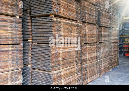 Stapel von Holzpaletten. Innenraum des Produktionslagers. Anlage zur Herstellung von Pflasterplatten Stockfoto