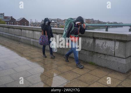März 2024 . Fußgänger kämpfen mit den nassen und bliusterartigen Bedingungen auf der Putney Bridge, London, während der Sturm Nelson in den nächsten 24 Stunden mit starken Winden und starkem Regen in Großbritannien treffen wird. Quelle: amer Gazzal/Alamy Live News Stockfoto