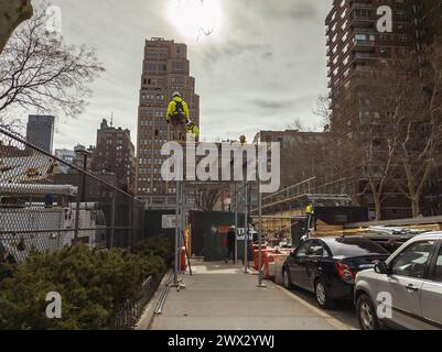 Arbeiter bauen am Dienstag, den 26. März 2024, auf einer Baustelle in Chelsea in New York eine Gehsteigerbrücke zum Schutz der Fußgänger. (© Richard B. Levine) Stockfoto