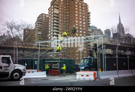 Arbeiter bauen am Dienstag, den 26. März 2024, auf einer Baustelle in Chelsea in New York eine Gehsteigerbrücke zum Schutz der Fußgänger. (© Richard B. Levine) Stockfoto