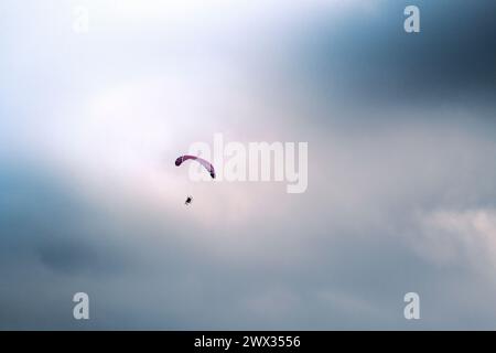 Ein motorisierter Paraglider, der über Newquay in Cornwall im Vereinigten Königreich fliegt. Stockfoto